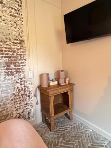 a room with a table with a television on a wall at Lizzy's B&B in Maarssen