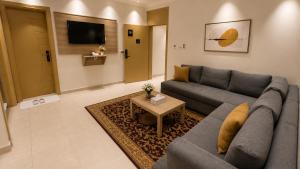 a living room with a couch and a table at أمكو للشقق المخدومة in Jeddah