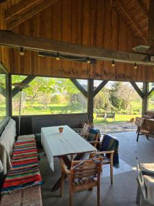 a room with a table and chairs in a pavilion at Pirts māja in Engure