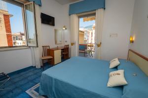 a bedroom with a blue bed and a balcony at Meublè Casa Mannini Rooms in Maiori
