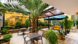 a patio with tables and chairs and plants at Mai İnci Otel in Antalya