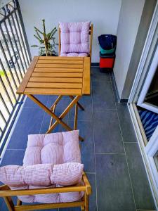 a balcony with pink chairs and a table and a table at Apartman DimDam in Veliko Gradište