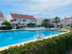 a large swimming pool in front of some houses at Casa Verde - Ground floor apartment next to the beach in Torrox Costa
