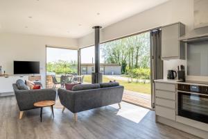 a living room with two couches and a kitchen at 2 Bed in Colchester oc-82397 in East Bergholt