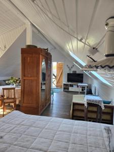 a bedroom with a bed and a living room at Pirts māja in Engure +10 photos