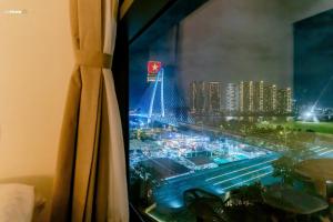 a window with a view of a city at night at ChiHome Metropole The Opera Residence Luxury in Ho Chi Minh City