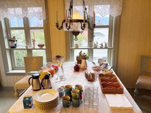 a table with plates and cups on top of it at Villa Solvorn in Solvorn