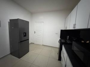 a kitchen with a black refrigerator and a door at Vantage Suite in Lilongwe +19 photos