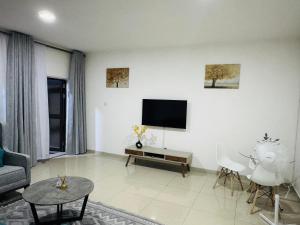 a living room with a couch and a tv on the wall at Vantage Suite in Lilongwe