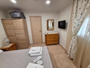 a bedroom with a bed and a dresser and a mirror at Chios Flower House in Agia Ermioni