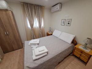 a bedroom with a bed with two towels on it at Chios Flower House in Agia Ermioni