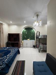 a bedroom with a bed and a couch and a window at Hostal Atlantis Middle World in Quito