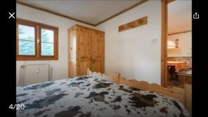 コー​​ニュにあるAppartamento Borealisのベッドルーム1室(ベッド1台付)、木製キャビネットが備わります。