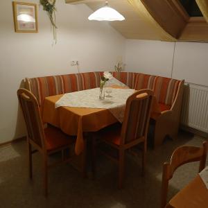 a dining room table with chairs and a vase of flowers on it at Gästezimmer Rauchecker Eging in Eging