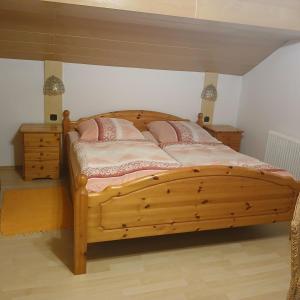 a bedroom with a wooden bed with two pink pillows at Gästezimmer Rauchecker Eging in Eging