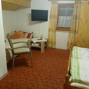 a living room with a couch and a tv at Gästezimmer Rauchecker Eging in Eging