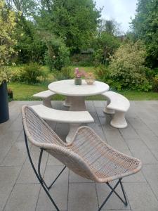 a white table and two chairs and a table with flowers at The Boathouse in Ballycotton +25 photos