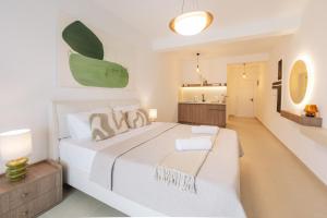 a white bedroom with a large bed and a bathroom at NUA Apartments in Ulcinj