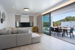 a living room with a couch and a dining room at Amalfi Twins Villa in Nydri