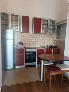 a kitchen with red cabinets and a table in it at Rafailovici Sea View in Rafailovici +16 photos
