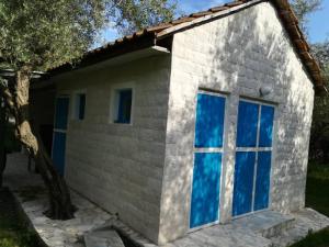 a small brick house with blue windows at Sabina Olive bungalow in Ulcinj