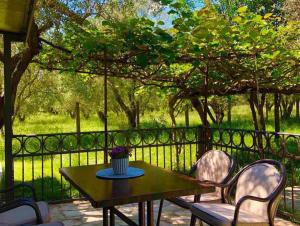 a table and chairs on a patio with a fence at Sabina Olive bungalow in Ulcinj