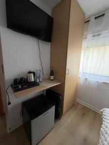 a small kitchen with a table with a television on the wall at Zimmer-Enjoy in Altenahr