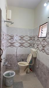 a bathroom with a toilet and a bucket in it at Trayi stay in Mysore