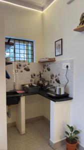 a kitchen with a counter top with pots and pans at Trayi stay in Mysore