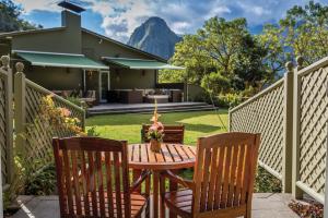 a patio with a table and chairs and a house at Sanctuary Lodge, A Belmond Hotel, Machu Picchu in Machu Picchu