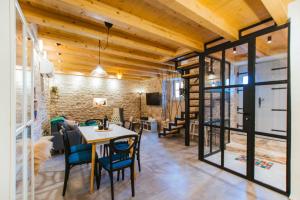a dining room with a table and chairs and a brick wall at Mala House - Šolta Island in Grohote +39 photos