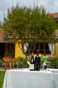 a table with three bottles of wine and glasses on it at Viña La Playa Hotel & Winery By Sutil Wines in Santa Cruz +31 photos