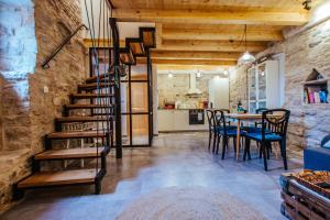 a room with a staircase and a table and chairs at Mala House - Šolta Island in Grohote