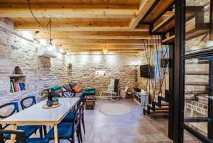a room with a stone wall and a table and chairs at Mala House - Šolta Island in Grohote
