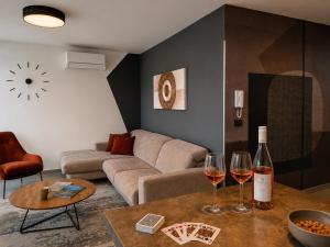 a living room with a couch and two glasses of wine at Visum Residence Labin - Luxury sea view retreat in Labin +44 photos