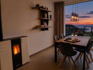 a dining room with a table and a fireplace at Visum Residence Labin - Luxury sea view retreat in Labin