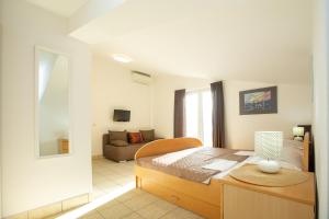a bedroom with a bed and a living room at Apartmani Liovic in Duće
