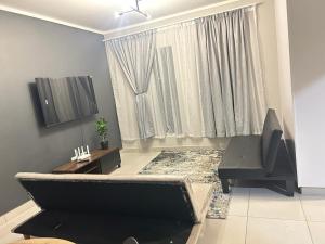 a living room with a couch and a television at Elisa's Haven in Matsulu