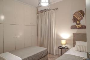 ein Schlafzimmer mit zwei Betten und einem Fenster und einer Lampe in der Unterkunft Arkadins in Zakynthos