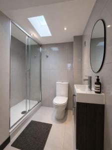 a bathroom with a toilet and a shower and a sink at The Regent in Warrington