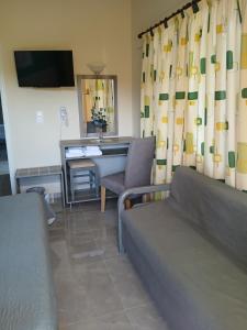 a living room with a couch and a desk at Hermes in Agia Marina Aegina