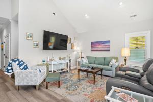 a living room with two couches and a tv at Chateau Relaxo by Oak Island Accommodations in Oak Island