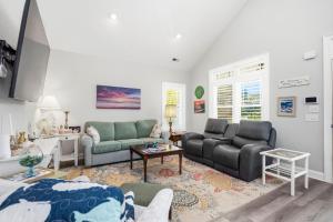 a living room with two couches and a table at Chateau Relaxo by Oak Island Accommodations in Oak Island +85 photos