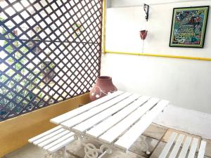 a white bench in front of a window with a vase at Casa Expocrato in Crato