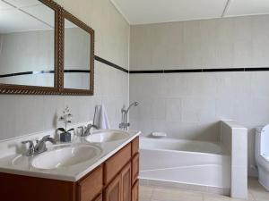 a bathroom with two sinks and a tub and a mirror at Spring Garden Ocean View in Montego Bay