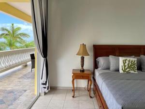 a bedroom with a bed and a table with a lamp at Spring Garden Ocean View in Montego Bay