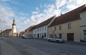 a street in a town with a clock tower at Spreeperle in Lübbenau