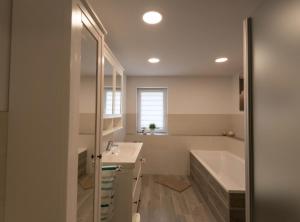 a bathroom with a tub and a sink and a bath tub at Spreeperle in Lübbenau +5 photos