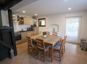 a kitchen and dining room with a wooden table and chairs at Spreeperle in Lübbenau