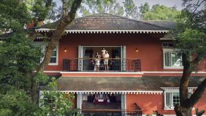 two people standing on a balcony of a house at Coorg Wilderness Resort & Spa in Madikeri